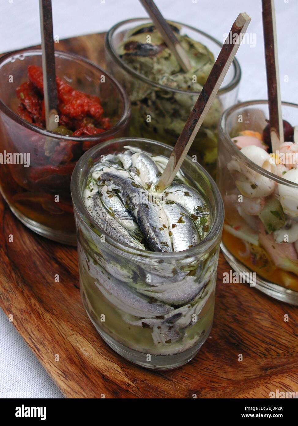 Selection of Itallian style antipast in small glass jars - Stock Photo