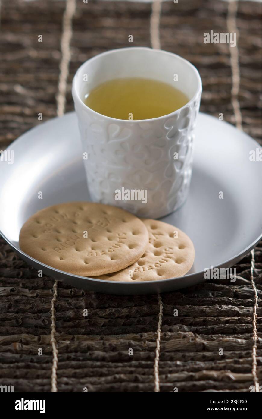 Light refreshment of herbal tea with plain biscuits - Stock Photo