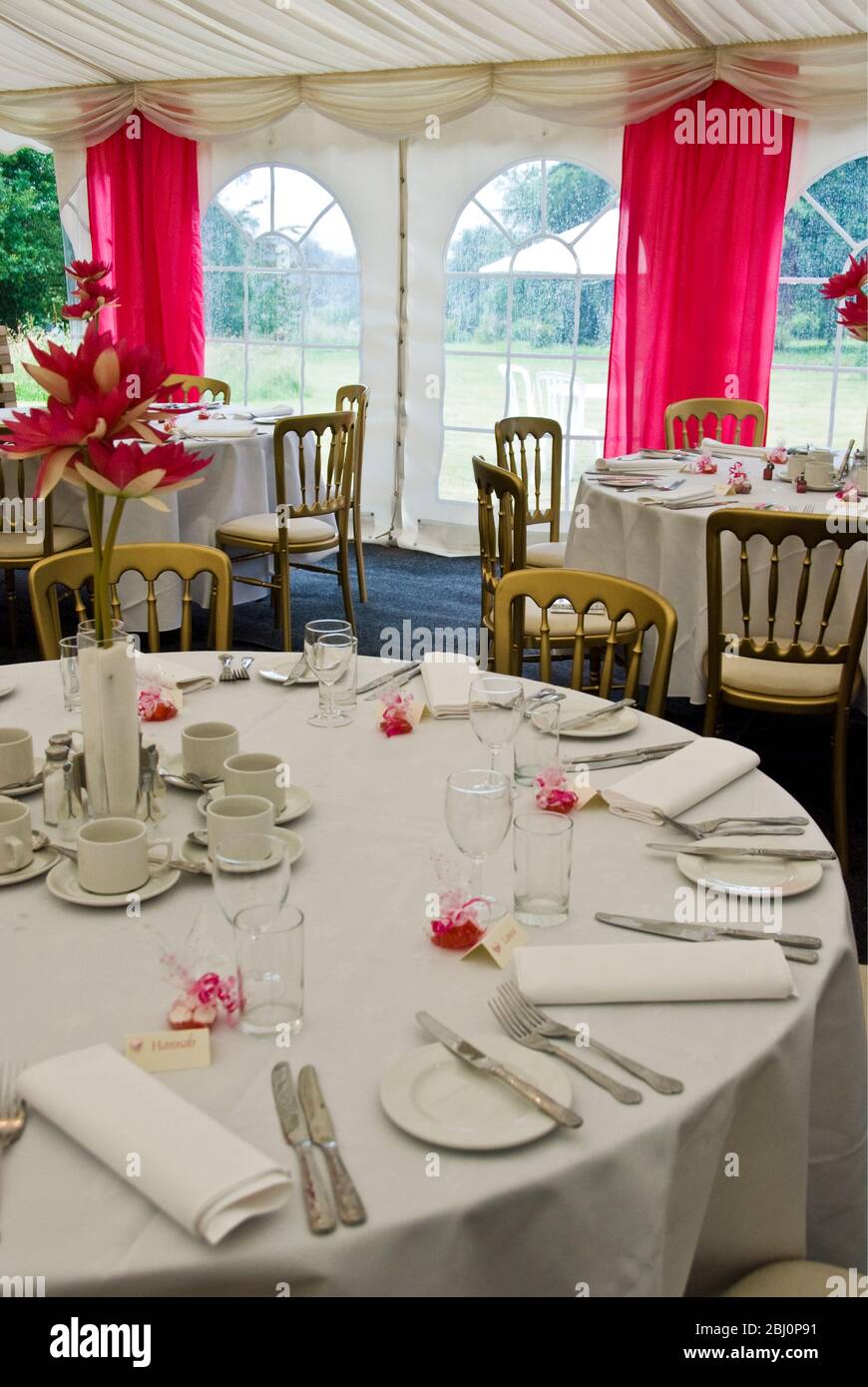 Interior of marquee decorated for a summer wedding in shades of pink and white - Stock Photo