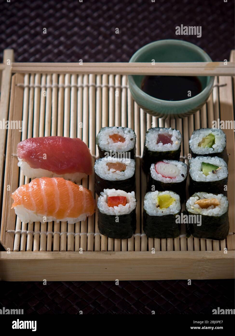 Sushi and sashimi on Japanese bamboo tray with soy sauce - Stock Photo