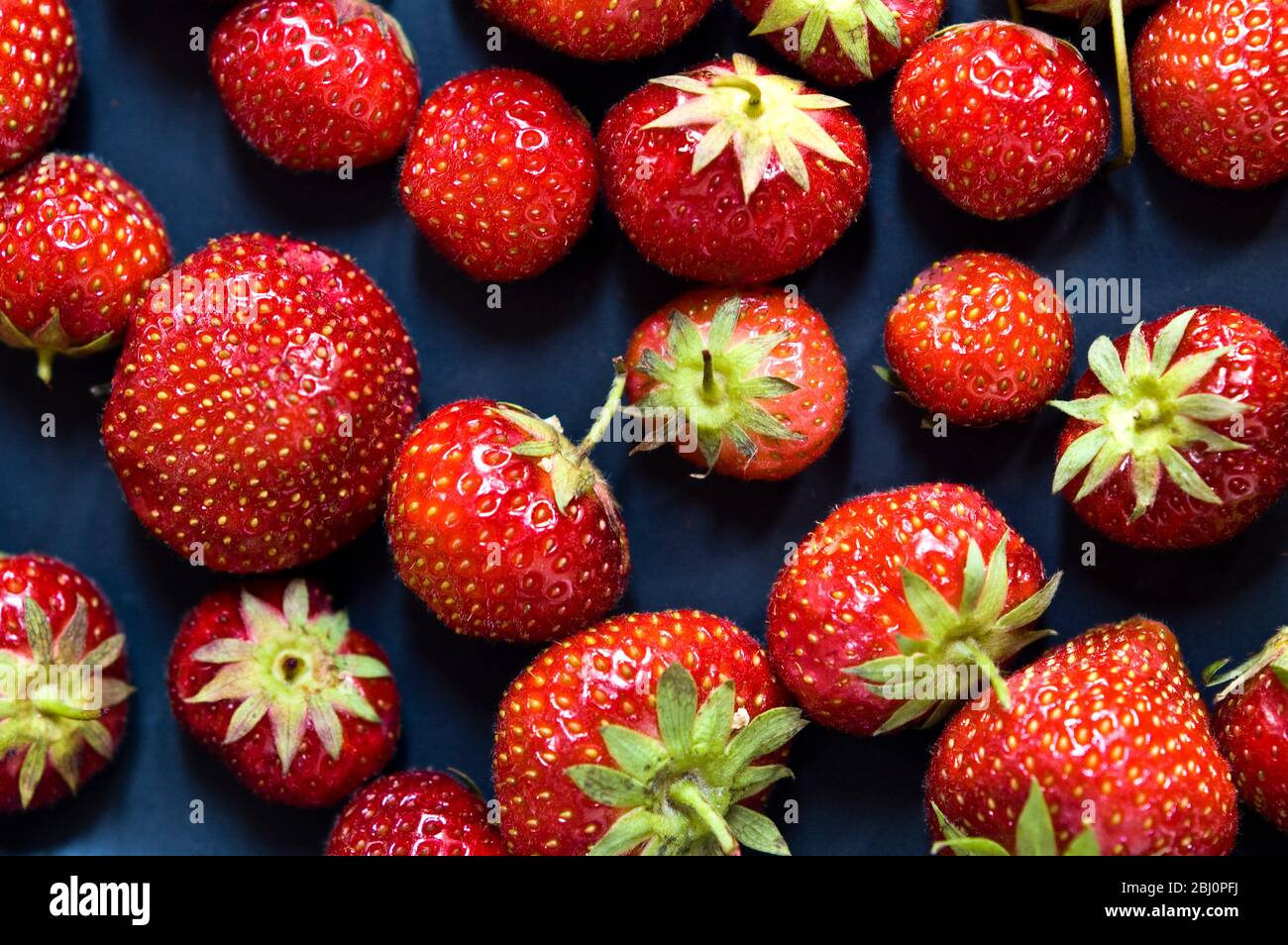 Black plate with red strawberries - Stock Photo