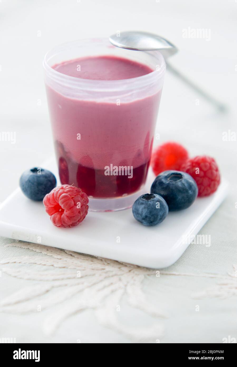 Little pot of layered raspberry and blueberry dessert - Stock Photo