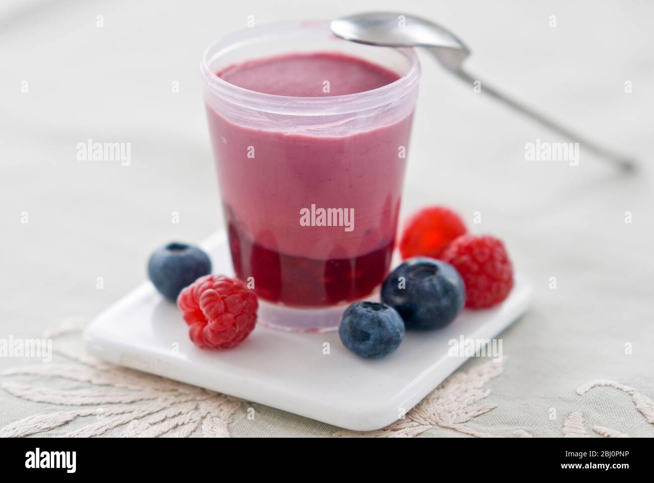 Little pot of layered raspberry and blueberry dessert - Stock Photo
