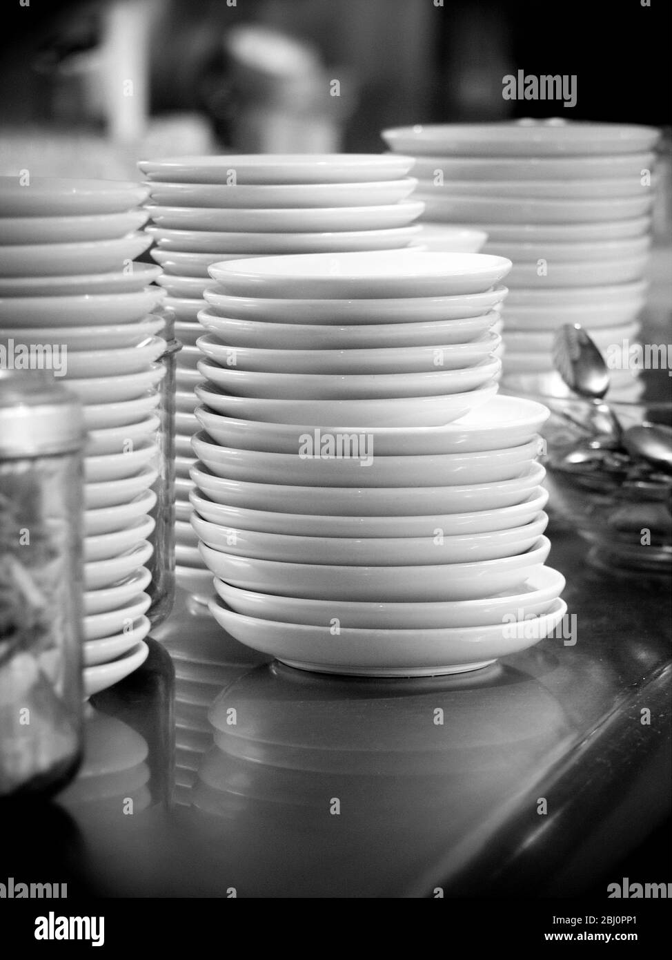 Stacks of plates on restaurant counter - Stock Photo