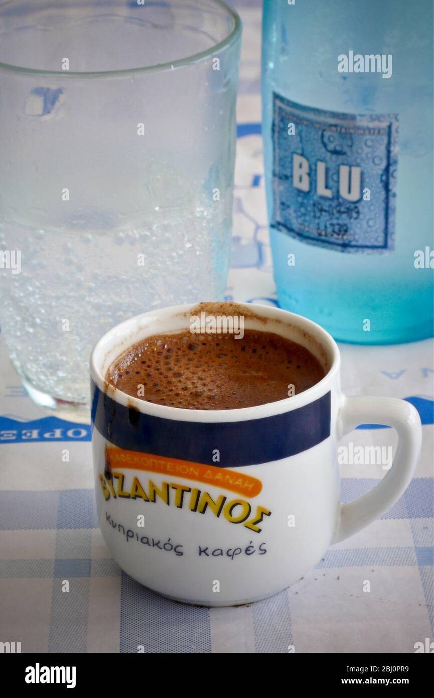 Small cup of sweet strong, Greek coffee on cafe table in southern Cyprus - Stock Photo