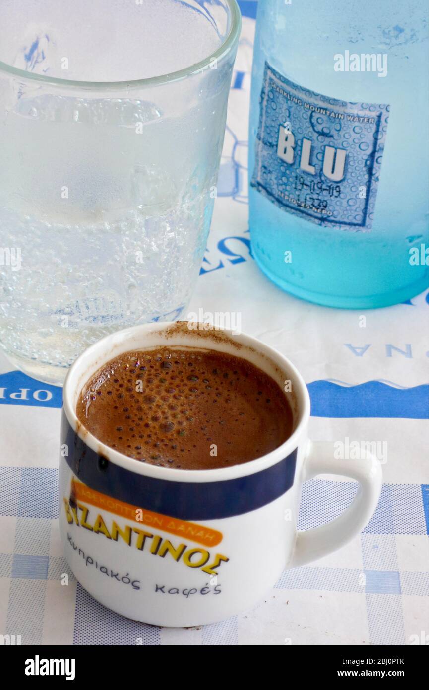Small cup of sweet strong, Greek coffee on cafe table in southern Cyprus - Stock Photo