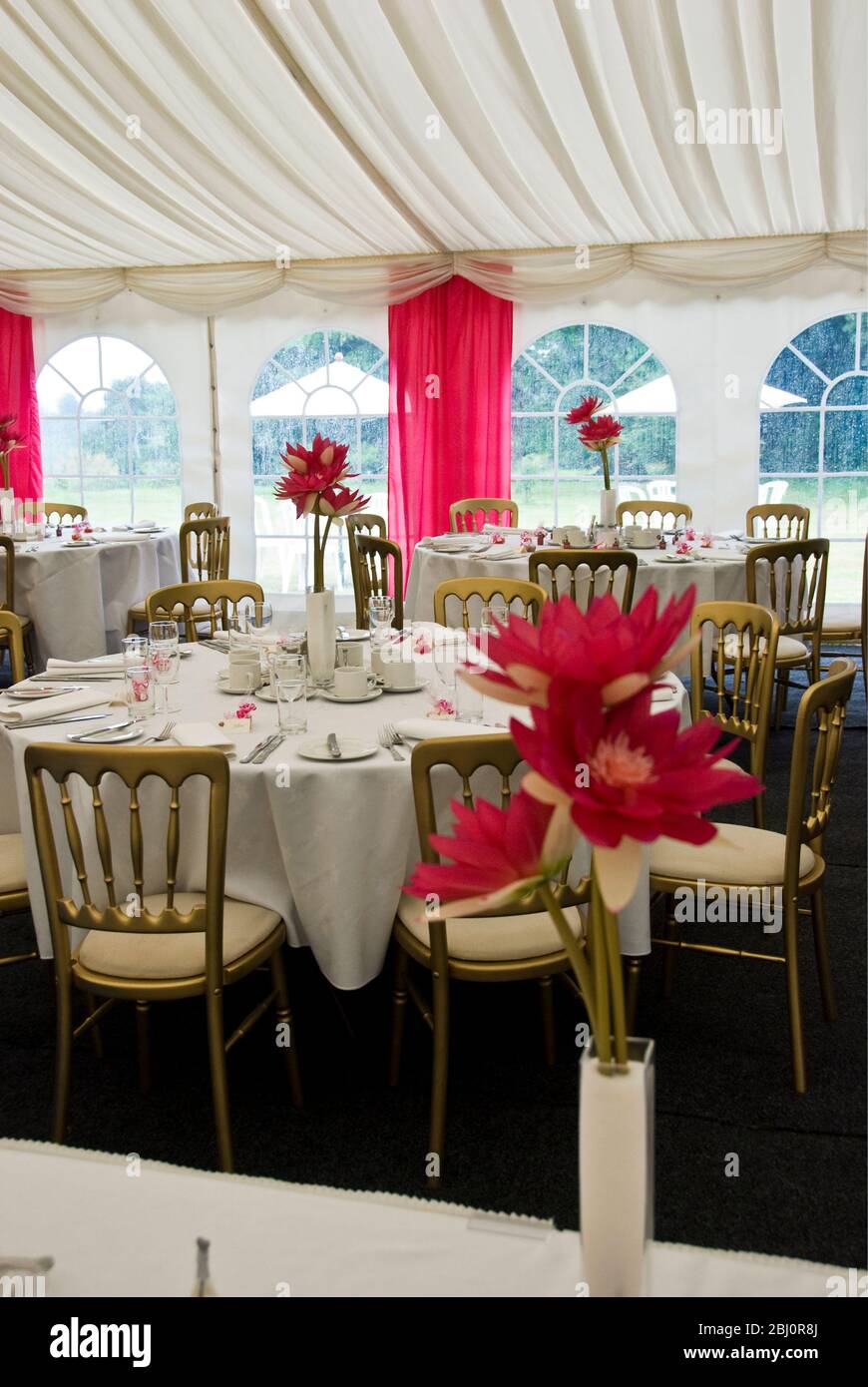 Interior of marquee decorated for a summer wedding in shades of pink and white - Stock Photo