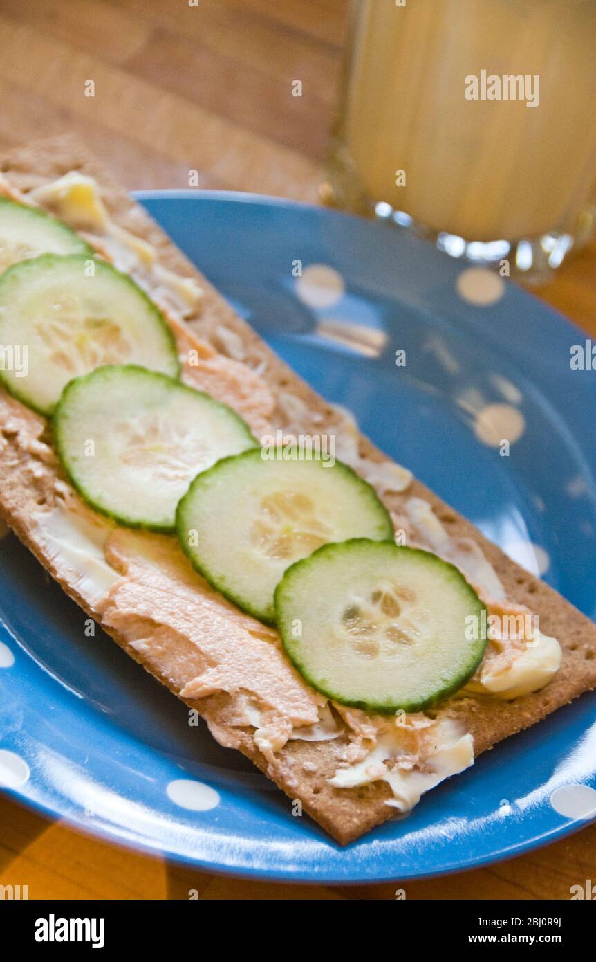Light snack of cucumber slices and curd cheese on thin, rye crispbread - Stock Photo