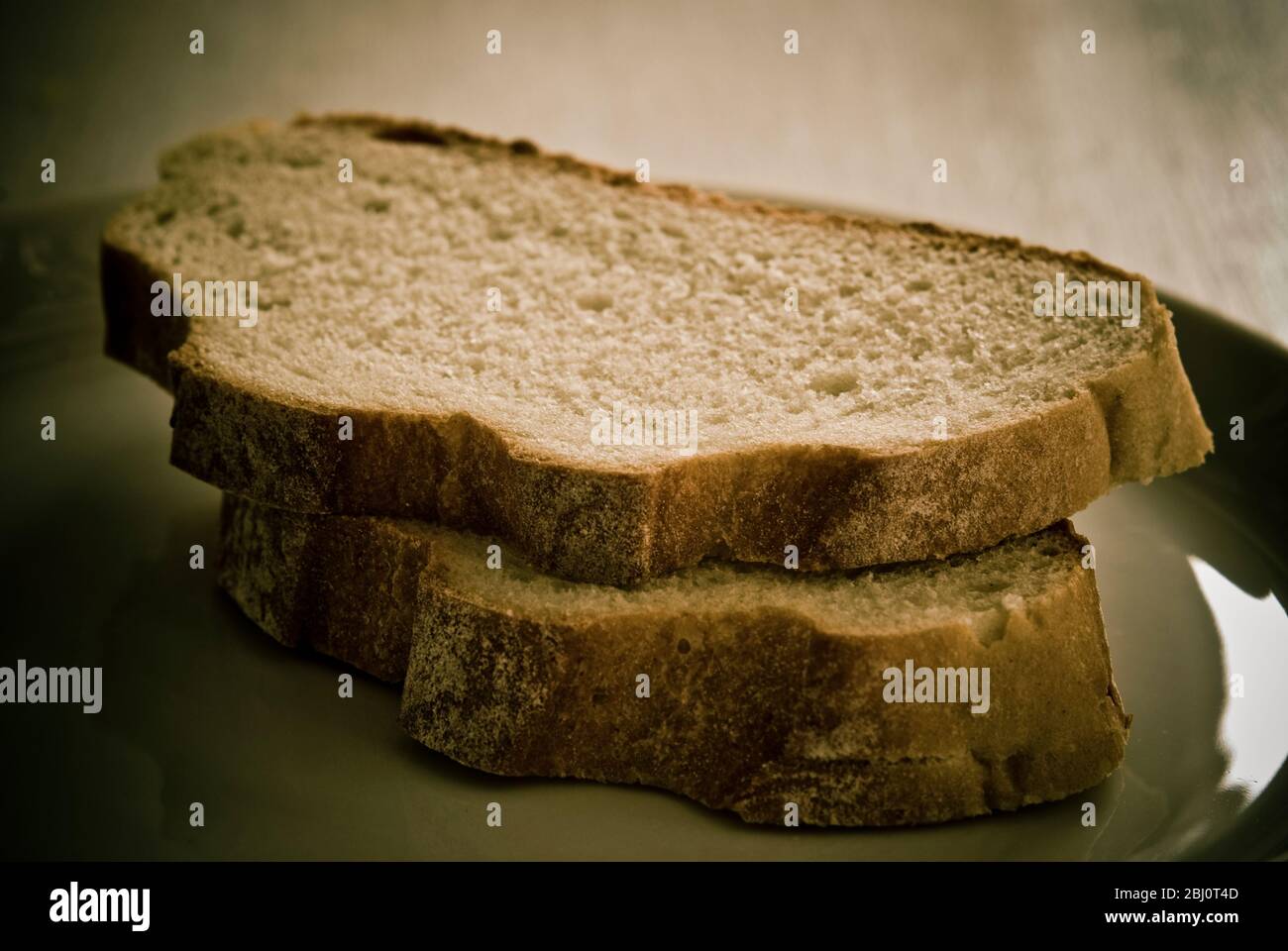 Two uneven slices of rustic bread - Stock Photo