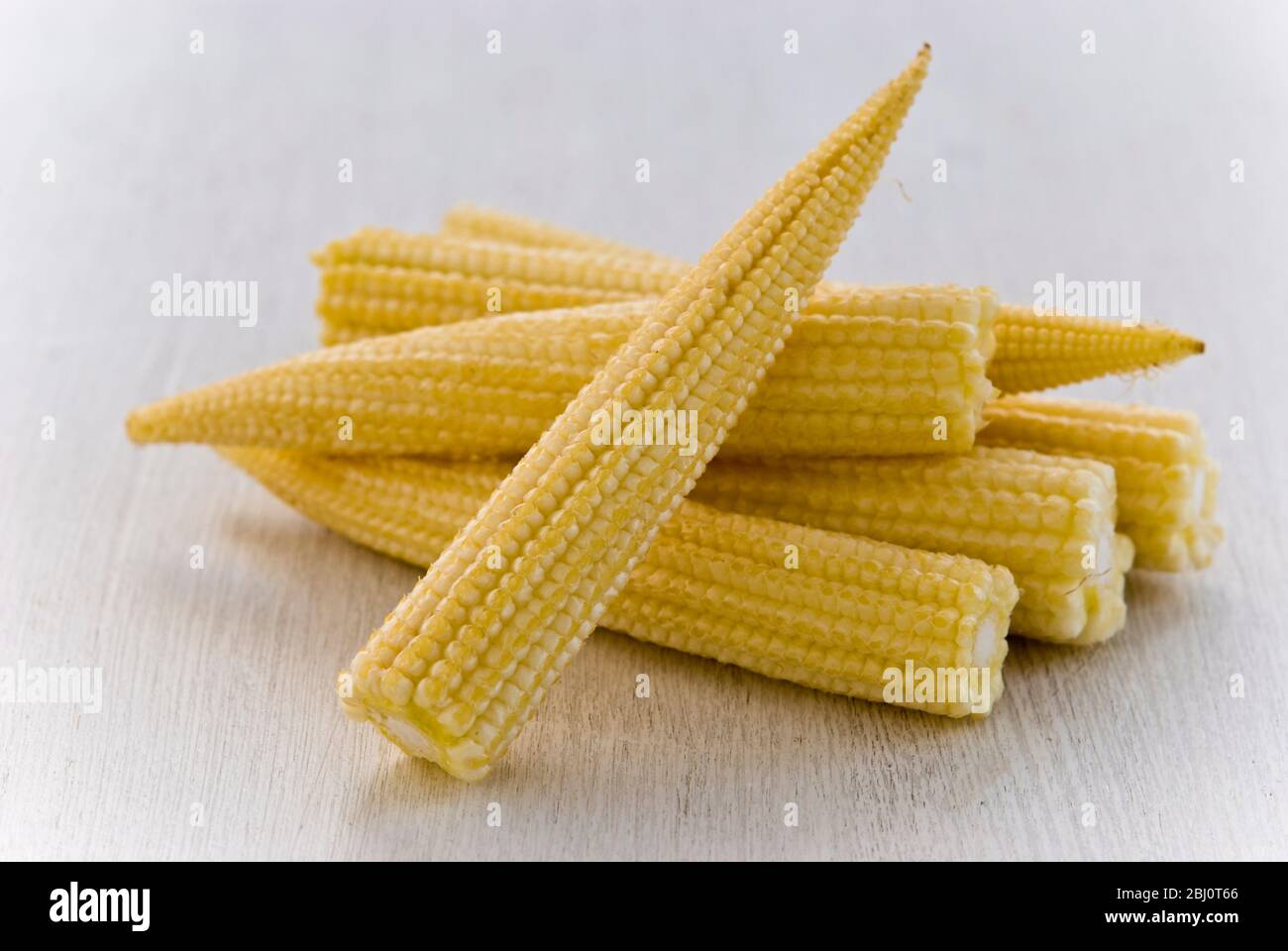 Small pile of baby sweetcorn on white background - Stock Photo