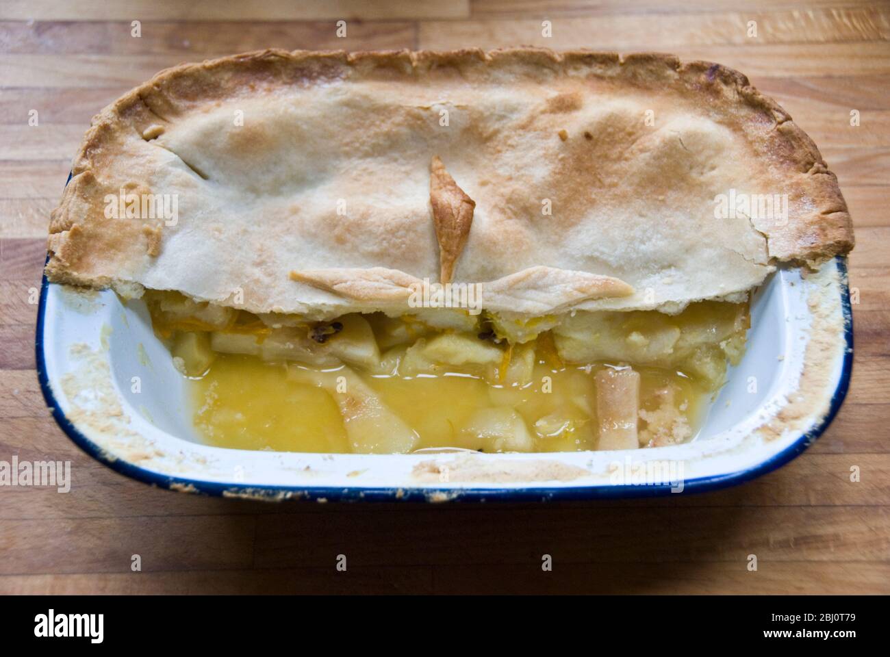 Half an apple pie in enamel pie dish - Stock Photo