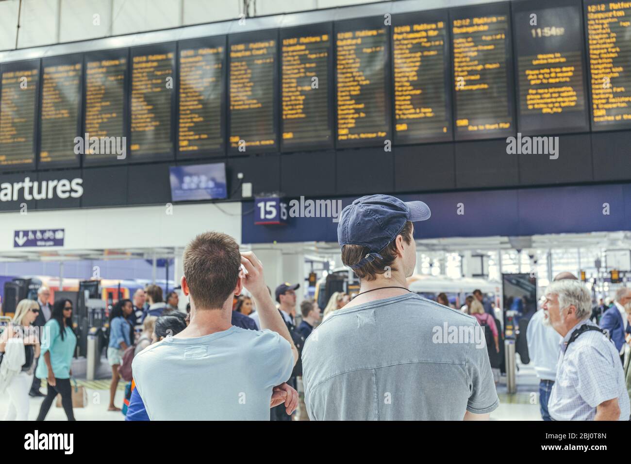 London/UK-1/8/19:young men waiting for their train at the London Waterloo station in a rush-hour. Central London terminus on the National Rail network Stock Photo