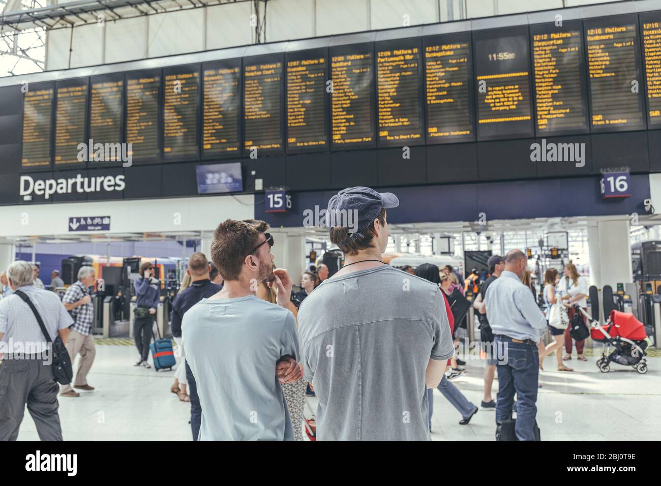 London/UK-1/8/19:young men waiting for their train at the London Waterloo station in a rush-hour. Central London terminus on the National Rail network Stock Photo