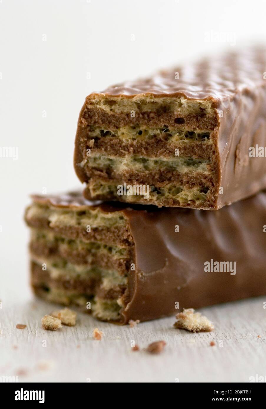 Chocolate wafer biscuit coated in chocolate, broken and stacked to show inside - Stock Photo