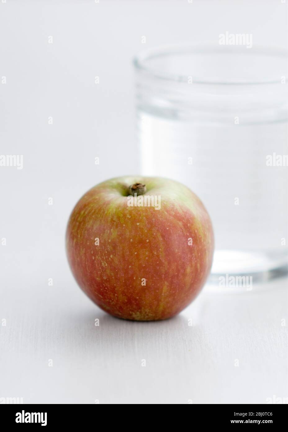 Very healthy light snack of fresh apple and glass of plain water - Stock Photo