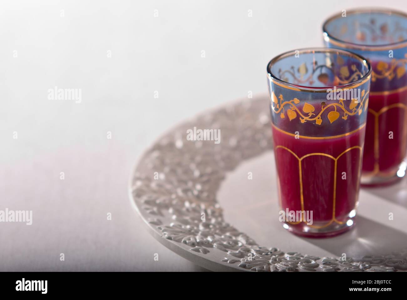 Pomegranate juice in ornate middle eastern tea glasses - Stock Photo
