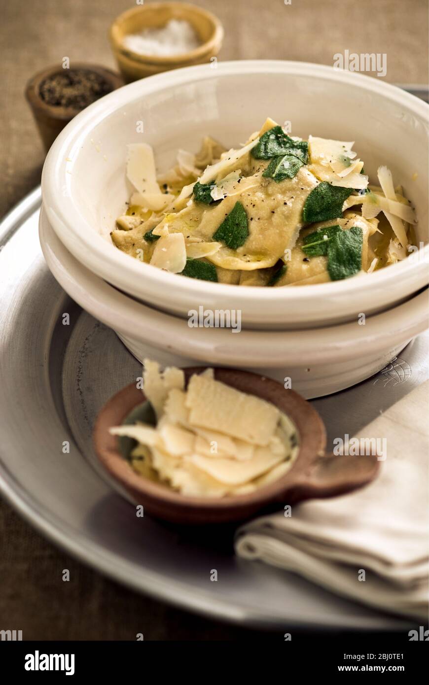 Home made pumpkin ravioli, with parmesan, slivers and sage leaves - Stock Photo