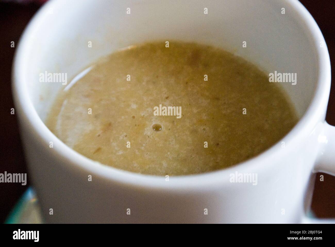 White china mug of warming home made vegetable soup. - Stock Photo