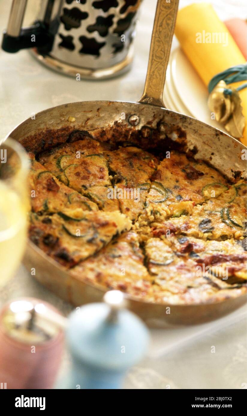 Frittata of courgettes and bacon served in frying pan - Stock Photo