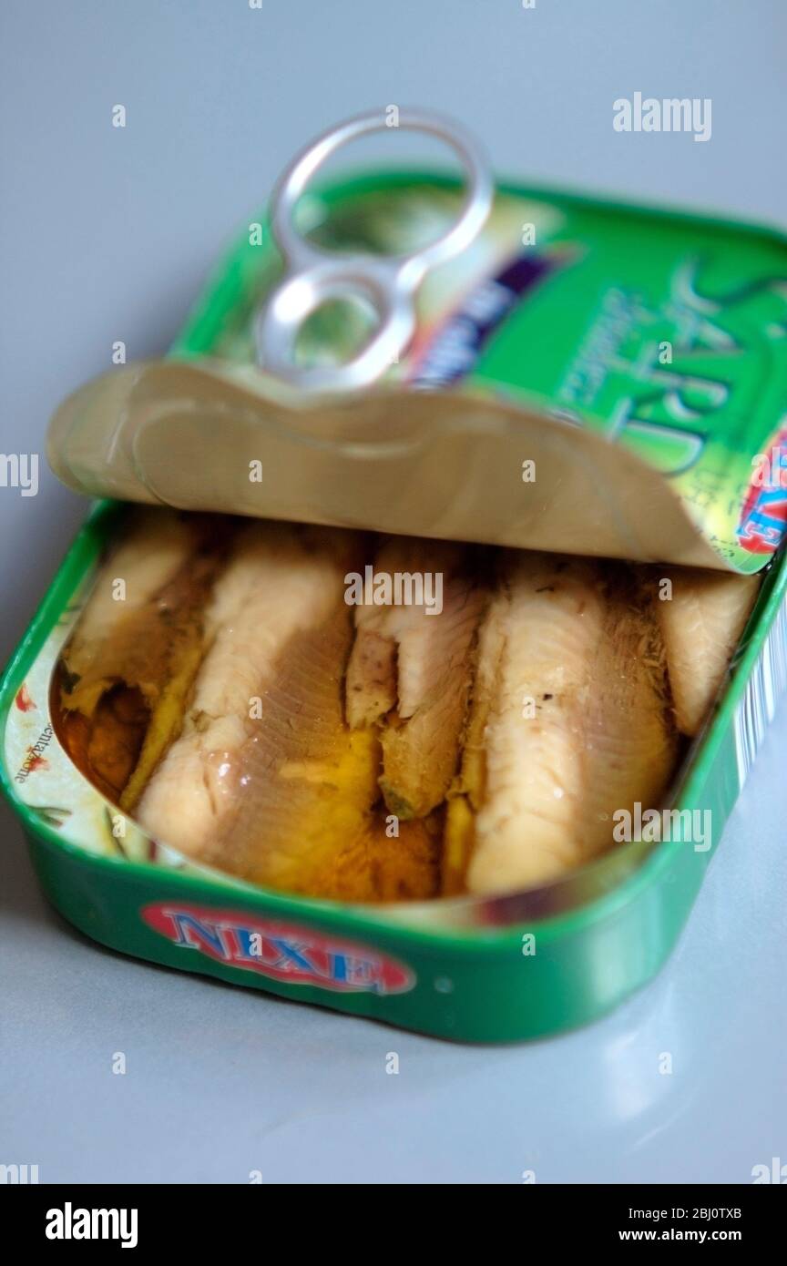 Can of sardine fillets opened showing tightly packed contents, in olive