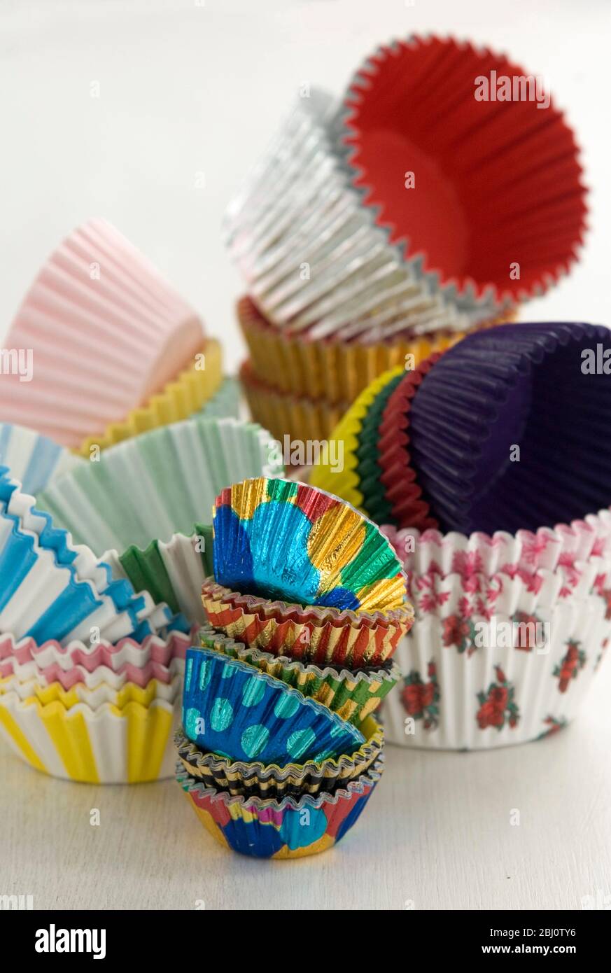 Variety of colourful muffin cases stacked high - Stock Photo