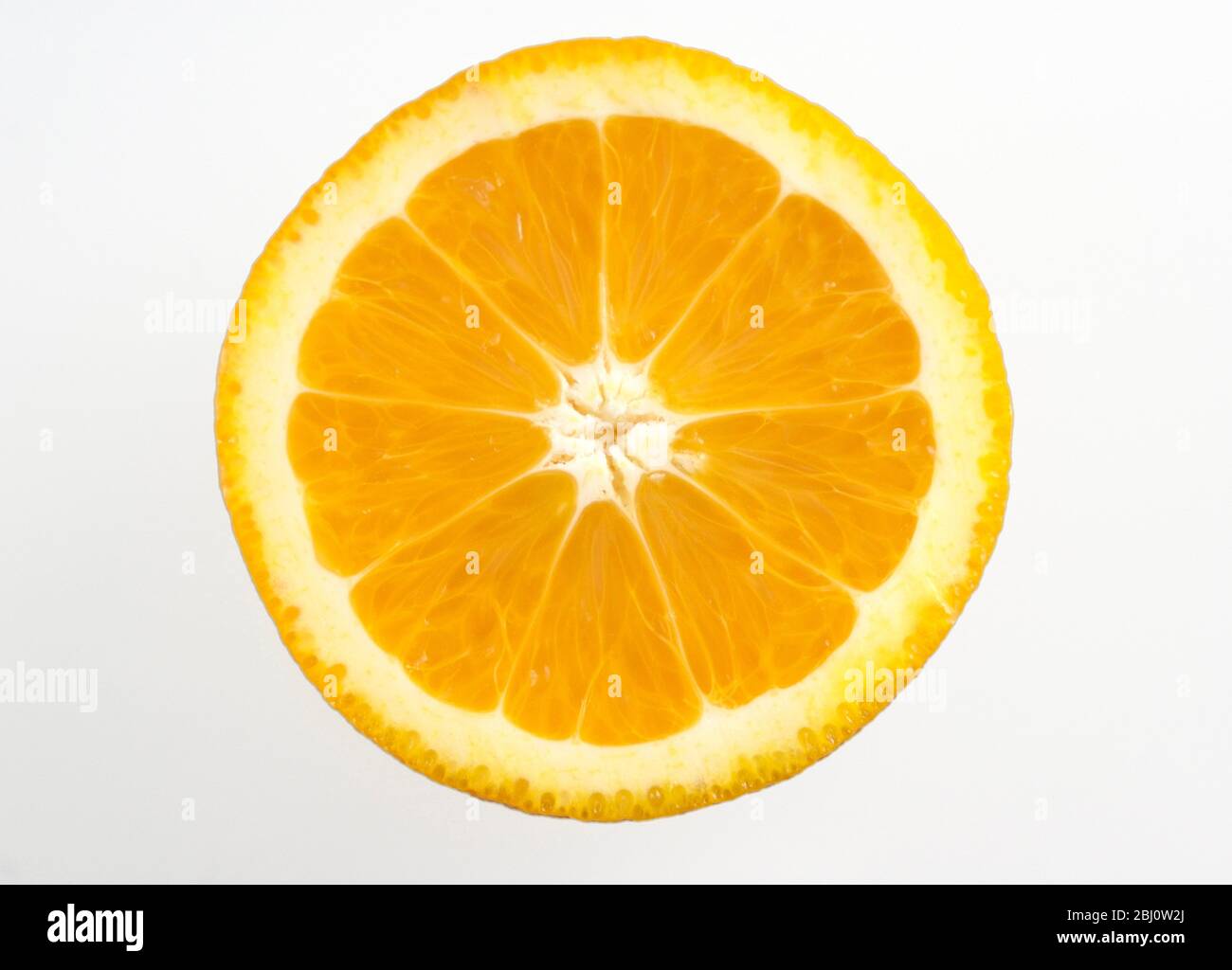 Cut face of half orange against white background - Stock Photo