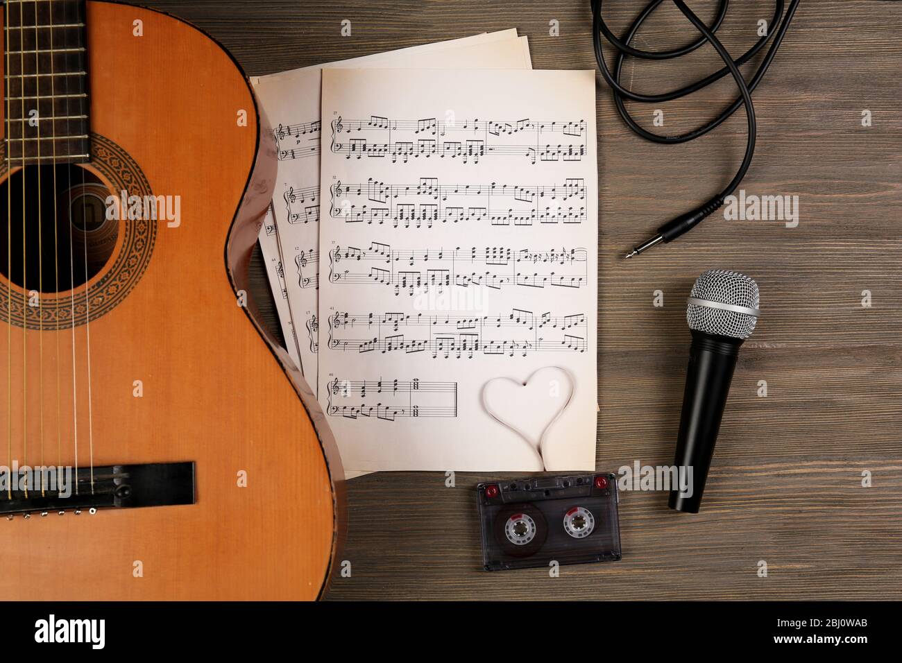Music recording scene with classical guitar, music sheets, cassette and