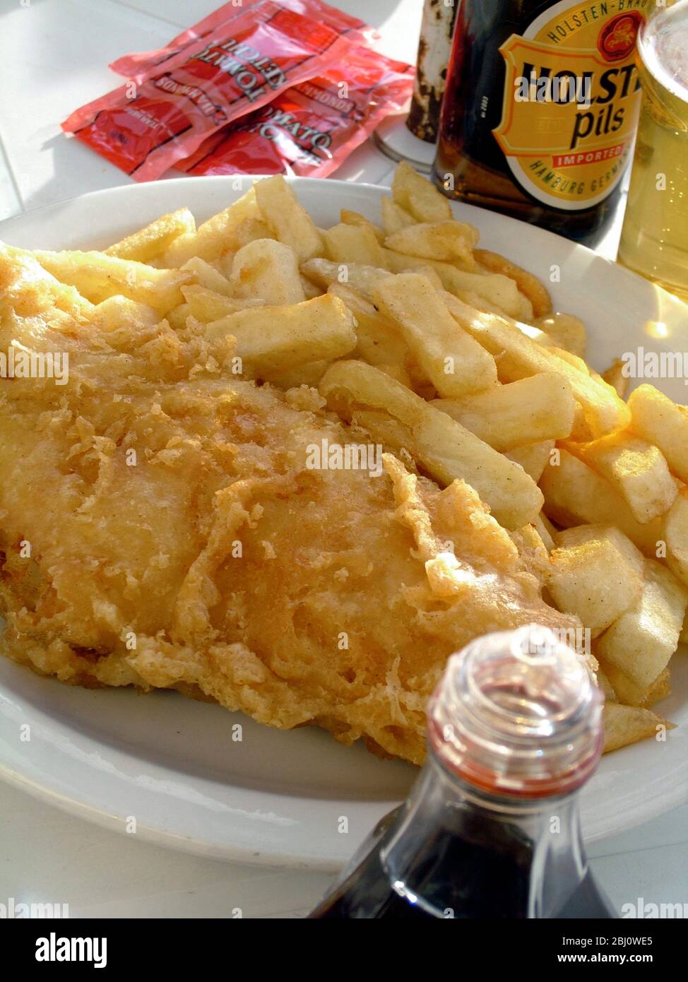 Traditional fish and chips at outdoor cafe on the seafront at Hastings - Stock Photo