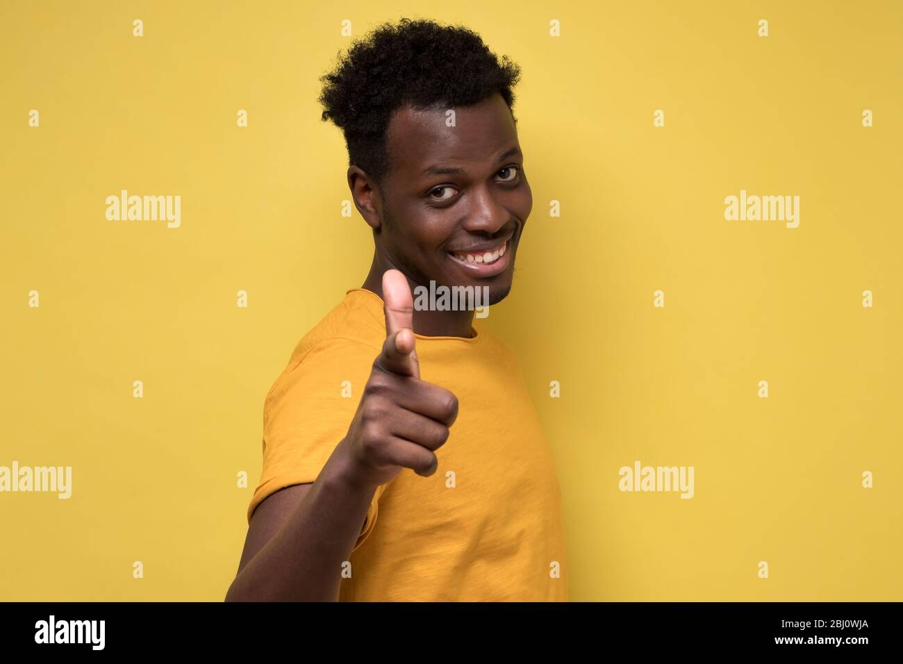 Cheerful attractive african man pointing on you making a choice. Stock Photo