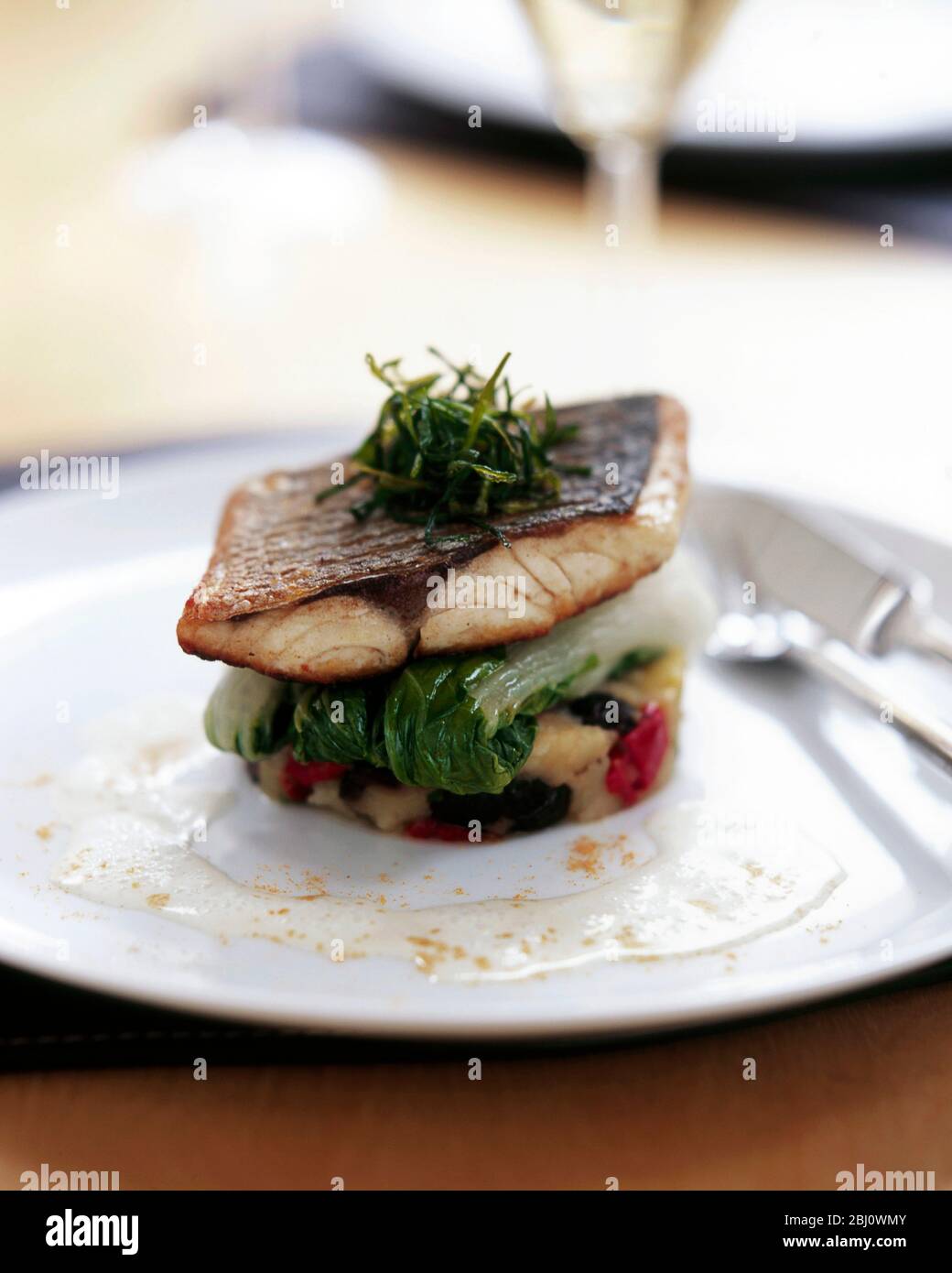 Pan fried sea bass on chard and vegetable mash - Stock Photo