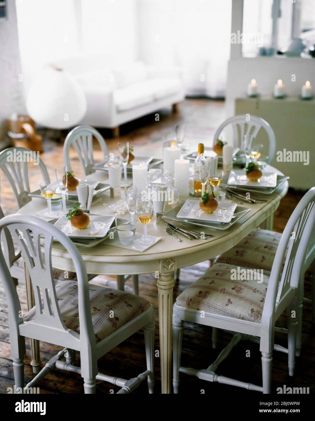 Celebration dinner tabel laid in chic studio style apartment - Stock Photo