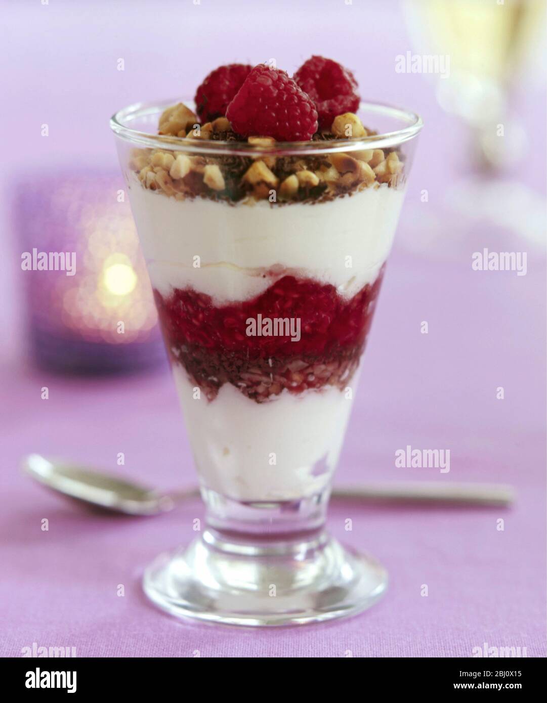 Raspberry sundae with chocolate, nuts and cream - Stock Photo