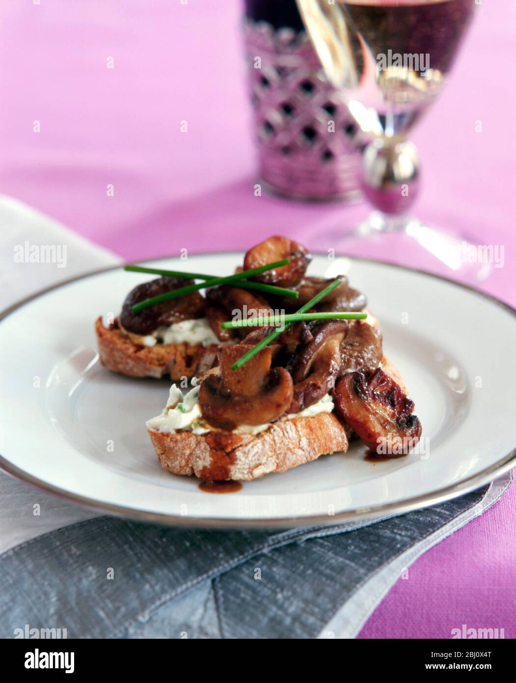 Mushrooms on ciabatta bread with chives - Stock Photo