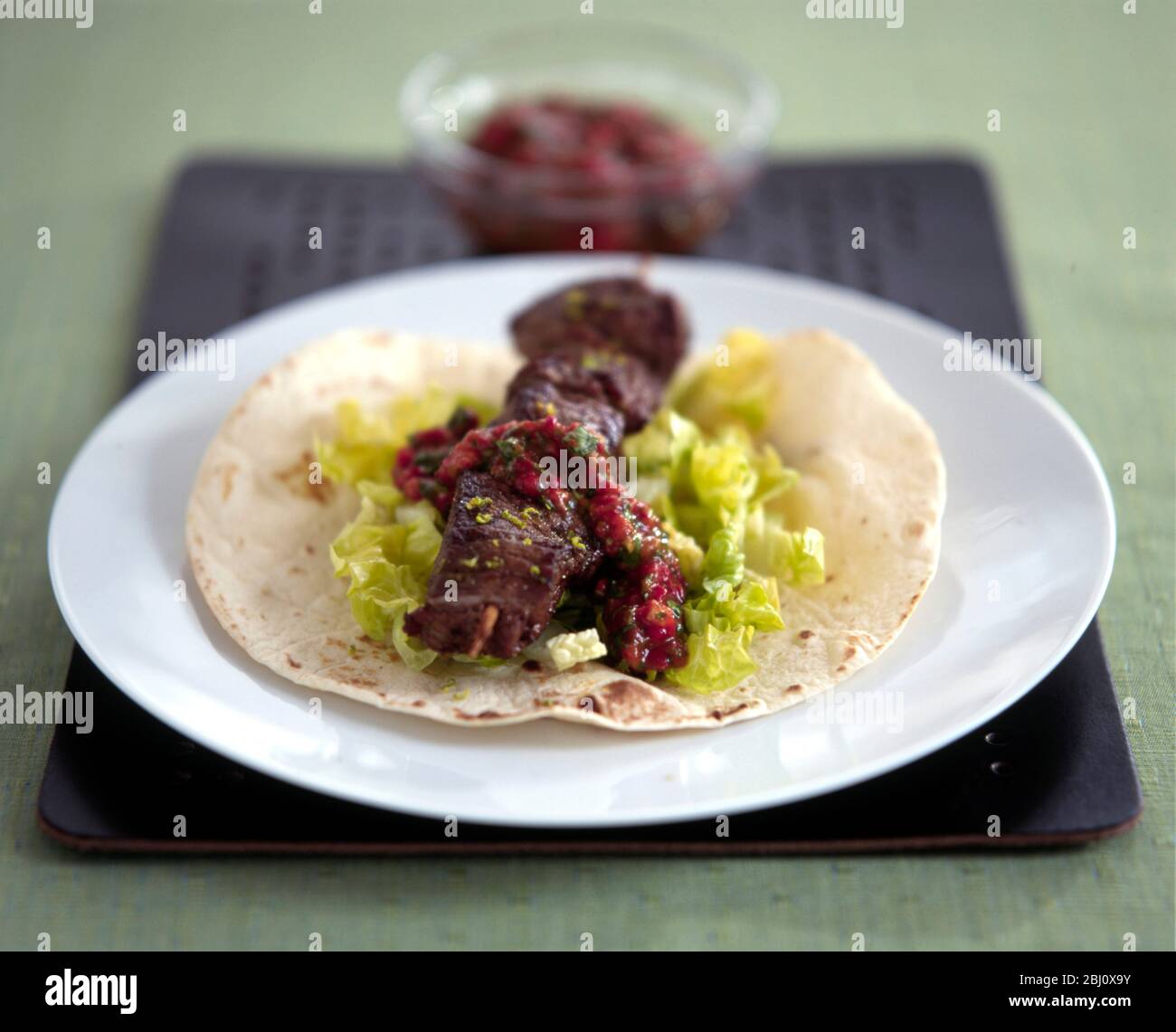 Lamb kebab with salad and fresh tomato sauce on turkish flat bread - Stock Photo