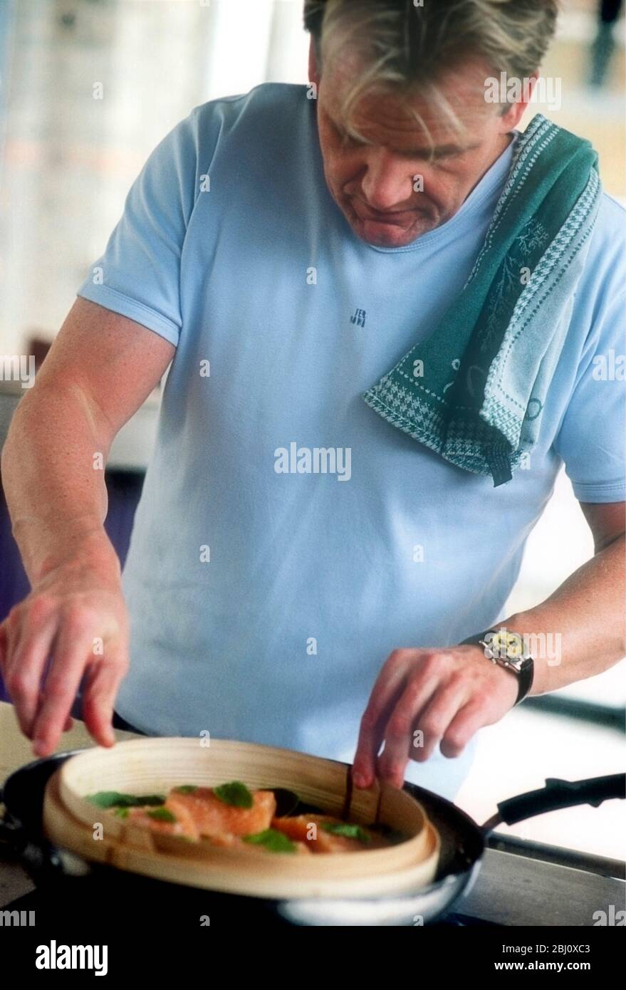 Gordon Ramsay cooking in his kitchen at home - Stock Photo