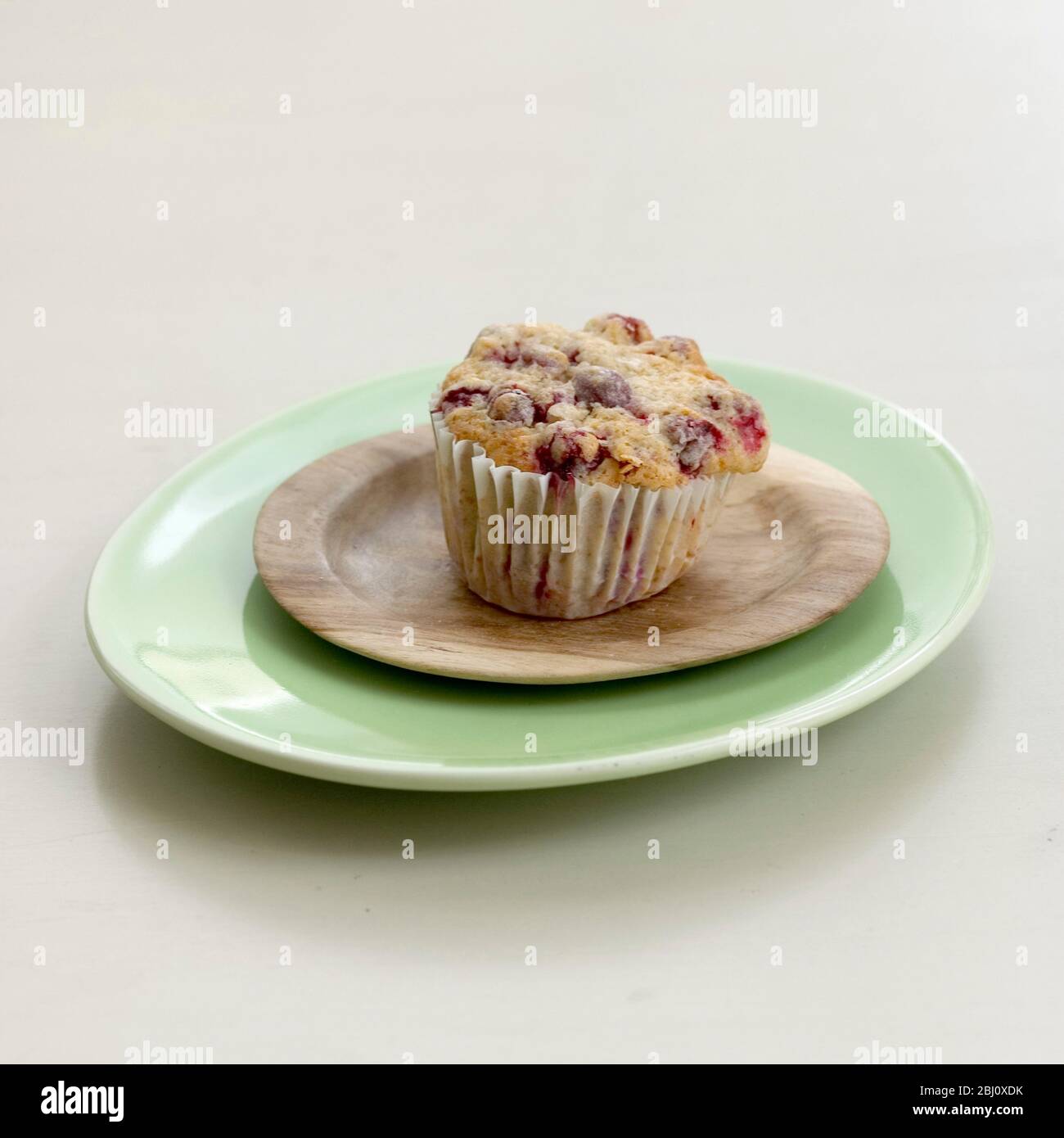 Sour cherry muffin in paper case on plates - Stock Photo