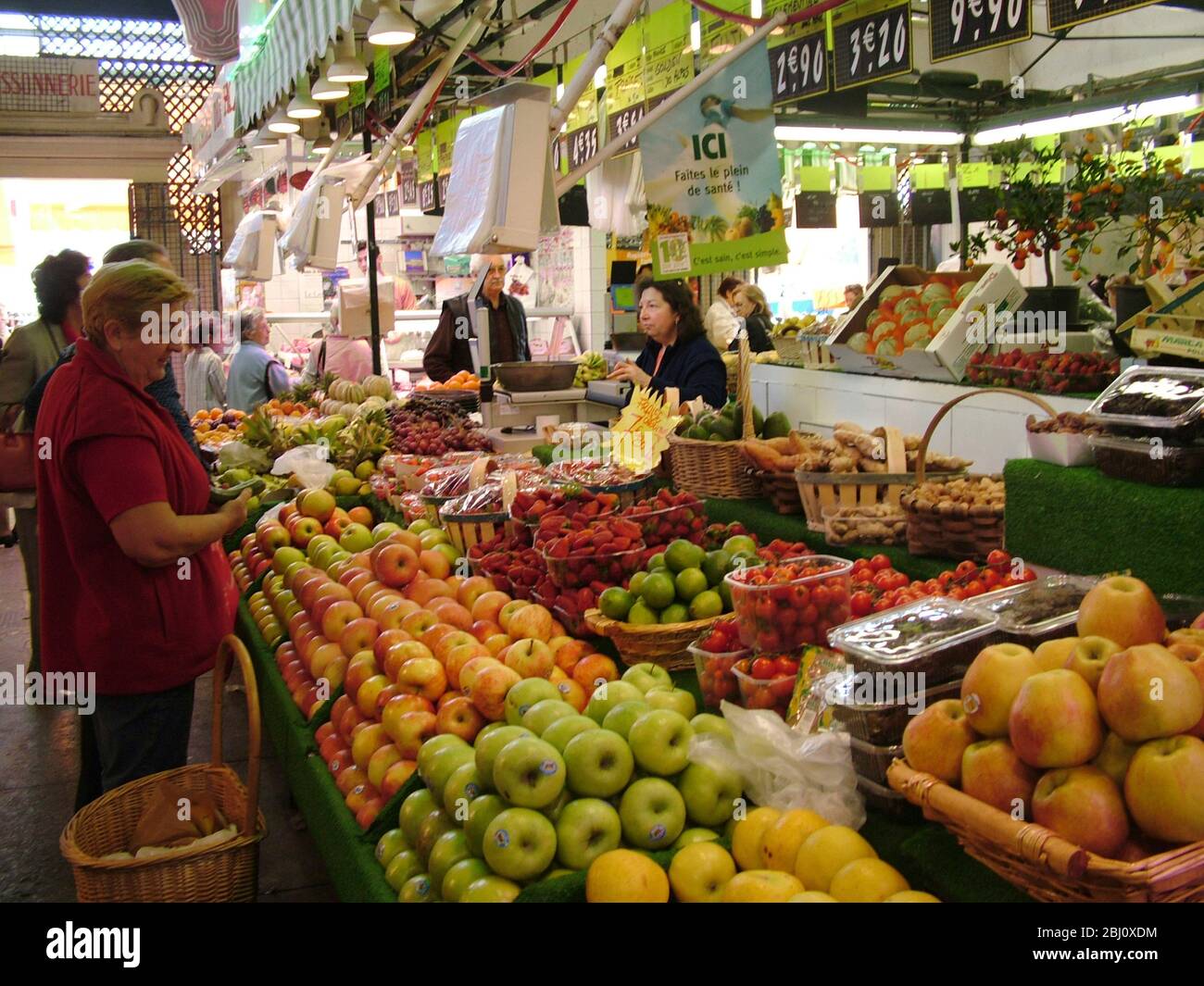 Shopping for fruit in the covered market in Menton, south of France - Stock Photo