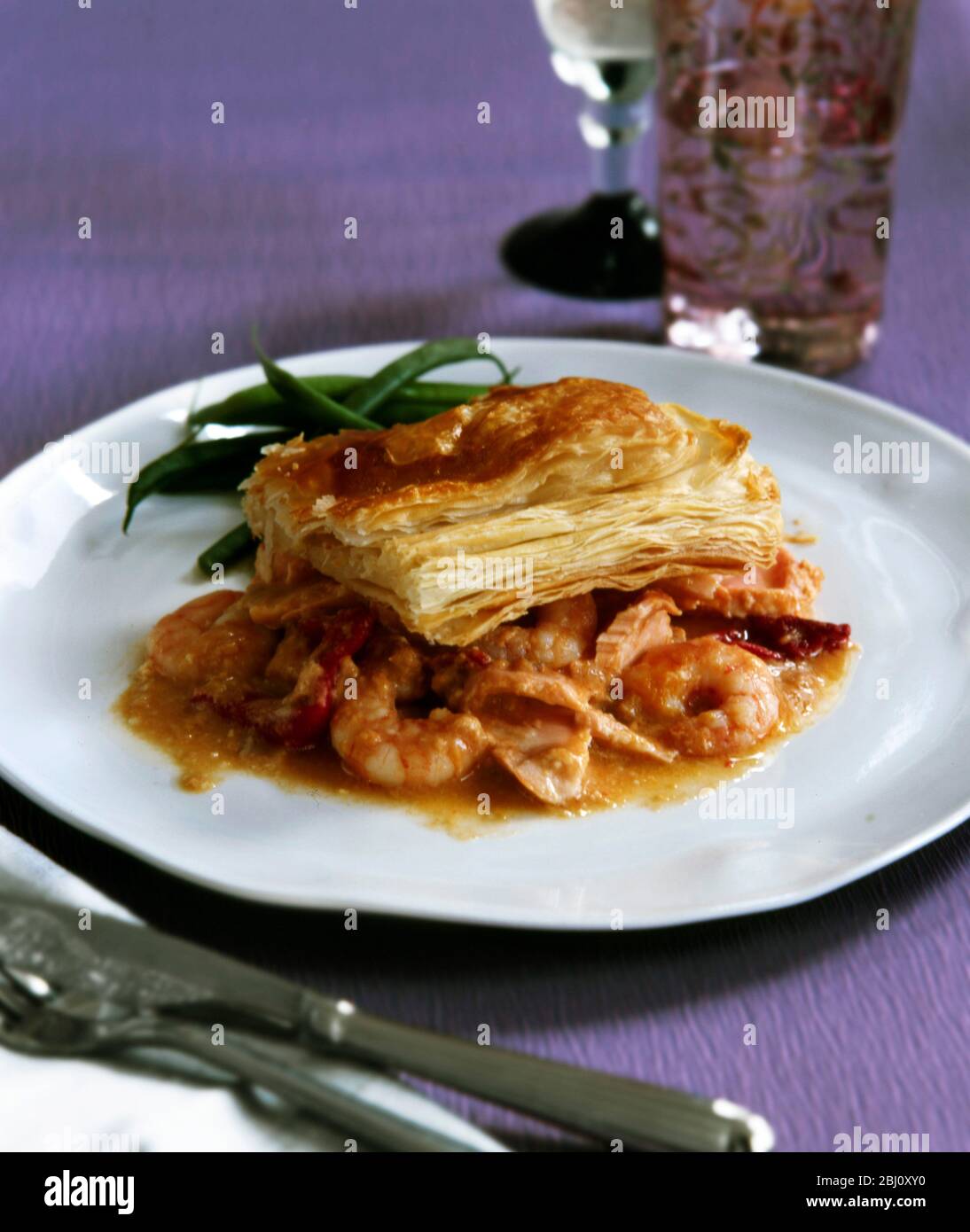 Festive dish of mixed seafood in wine infused sauce topped with puff pastry - Stock Photo