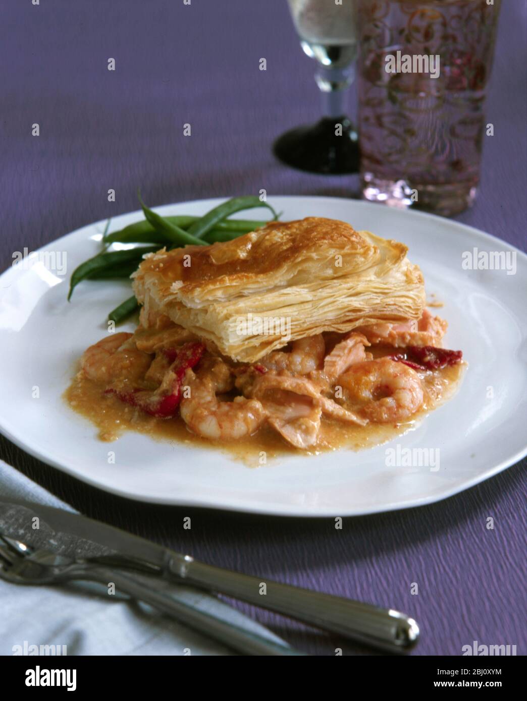 Festive dish of mixed seafood in wine infused sauce topped with puff pastry - Stock Photo