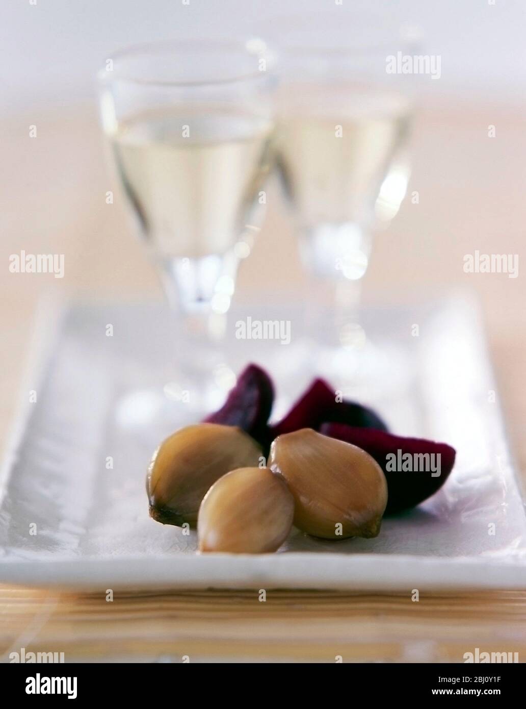 Pickled onions and beetroot pieces as accomopaniment to chilled white wine as an hors d'ouevre - Stock Photo