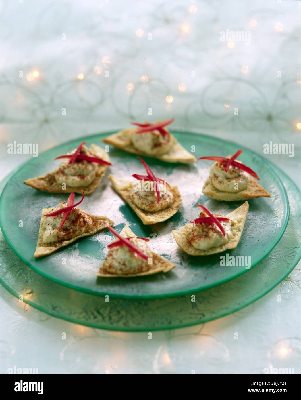 Party tray of canapes, home made houmous on toasted pitta with strips of red pepper - Stock Photo