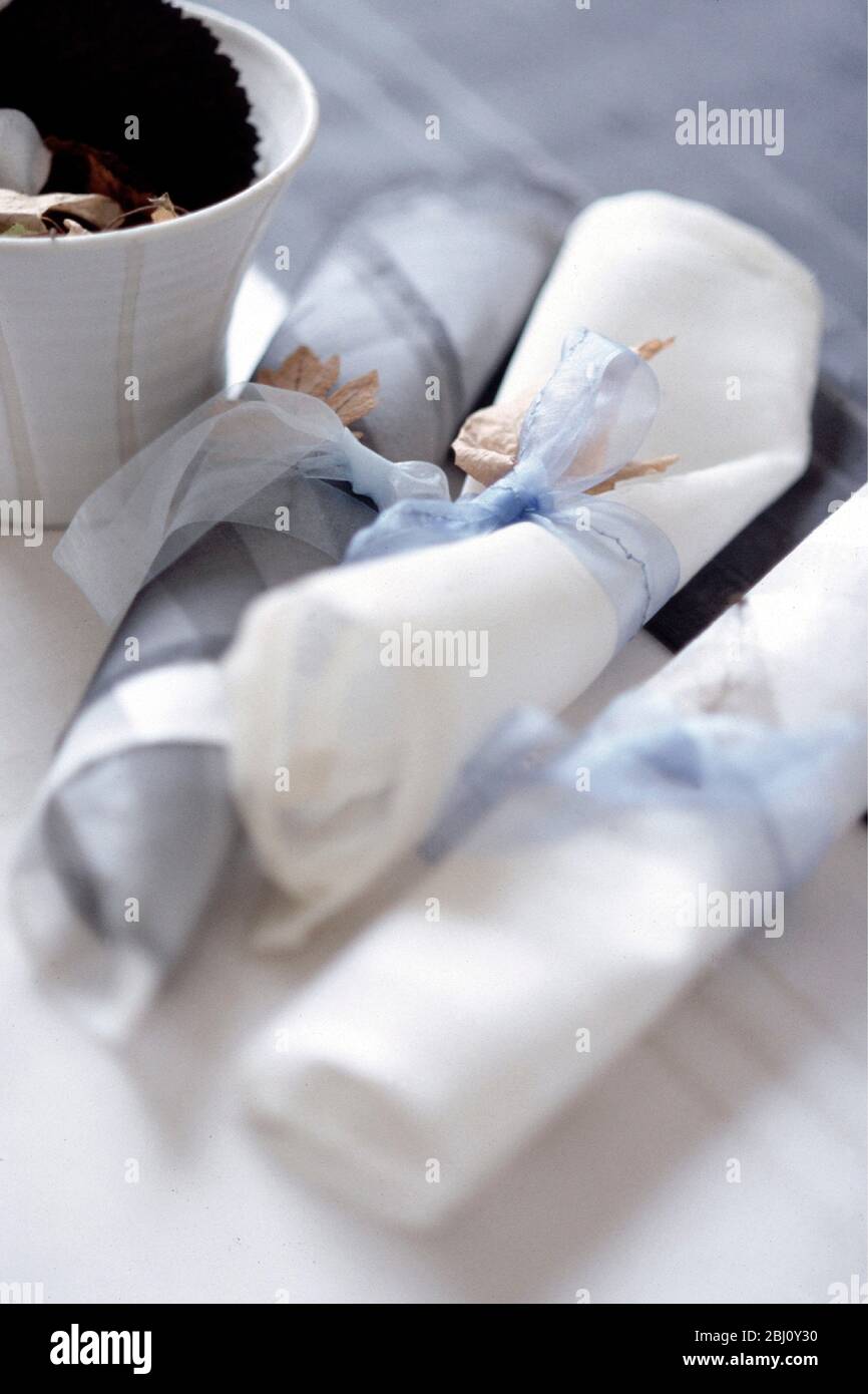 Light and delicate organza napkins tied up with organdie ribbon - Stock Photo