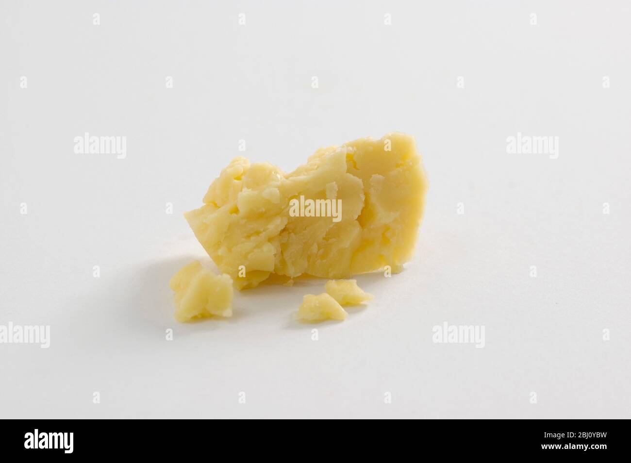 Cheddar cheese on white surface - Stock Photo