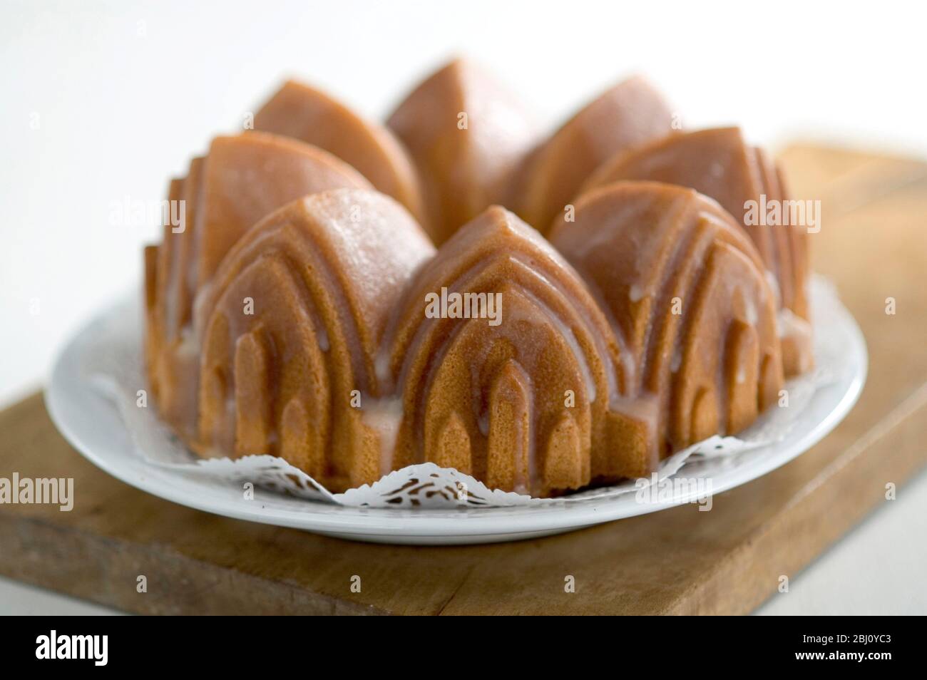 Classic pound cake baked in cathedral style Bundt tin, with sugar glaze - Stock Photo