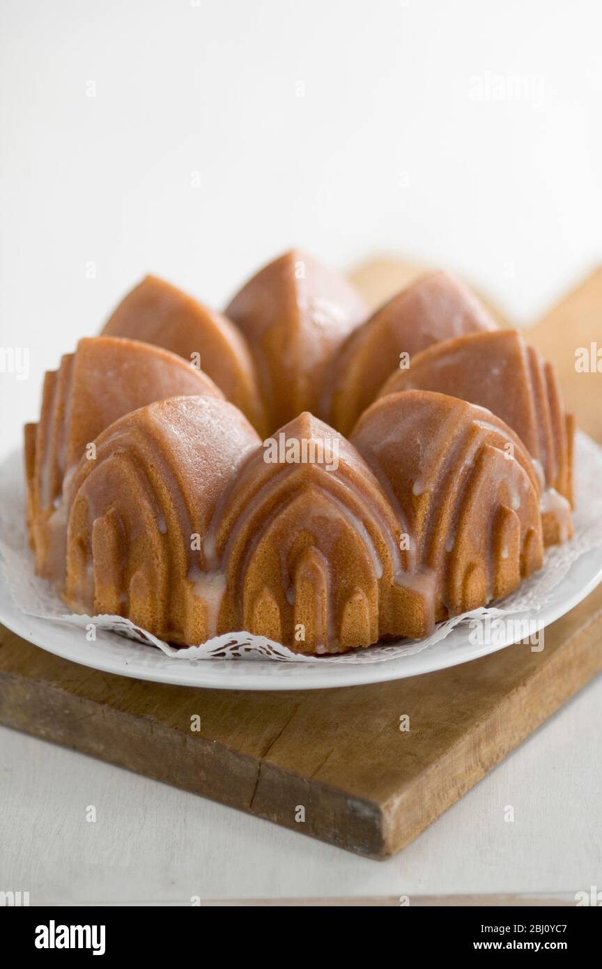 Classic pound cake baked in cathedral style Bundt tin, with sugar glaze - Stock Photo