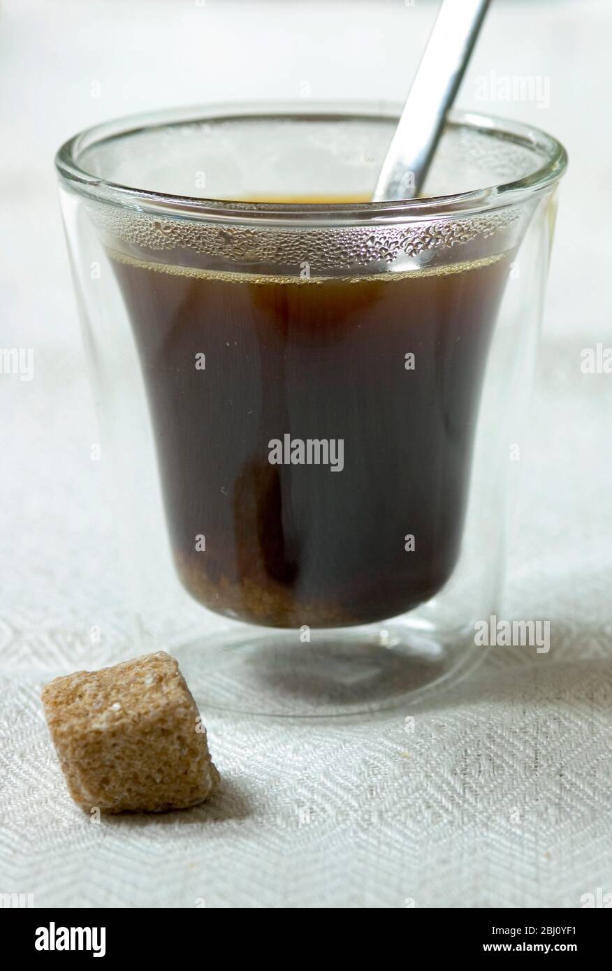 Bodum coffee glass with espresso coffee sugar lump and spoon on linen ...