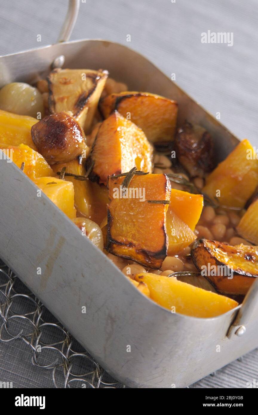 Roast root vegetables with olive oil and rosemary and baked beans - Stock Photo