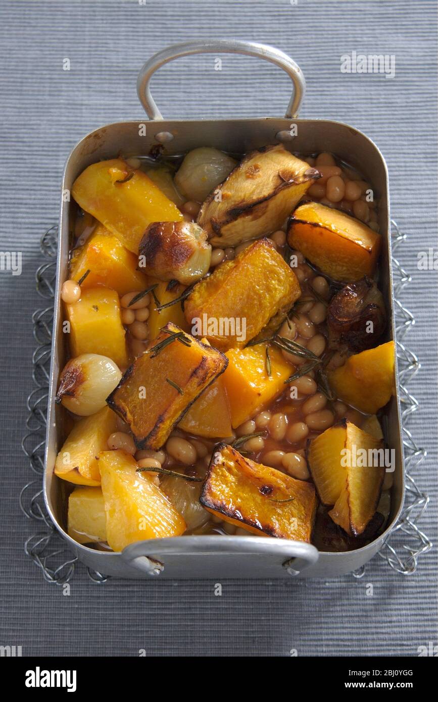 Roast root vegetables with olive oil and rosemary and baked beans - Stock Photo