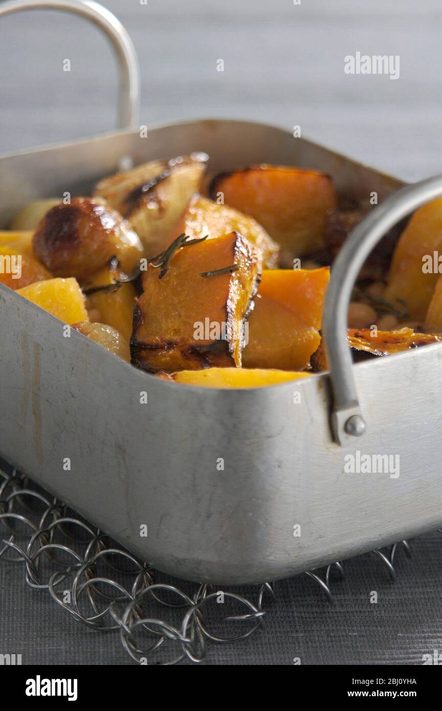 Roast root vegetables with olive oil and rosemary and baked beans - Stock Photo