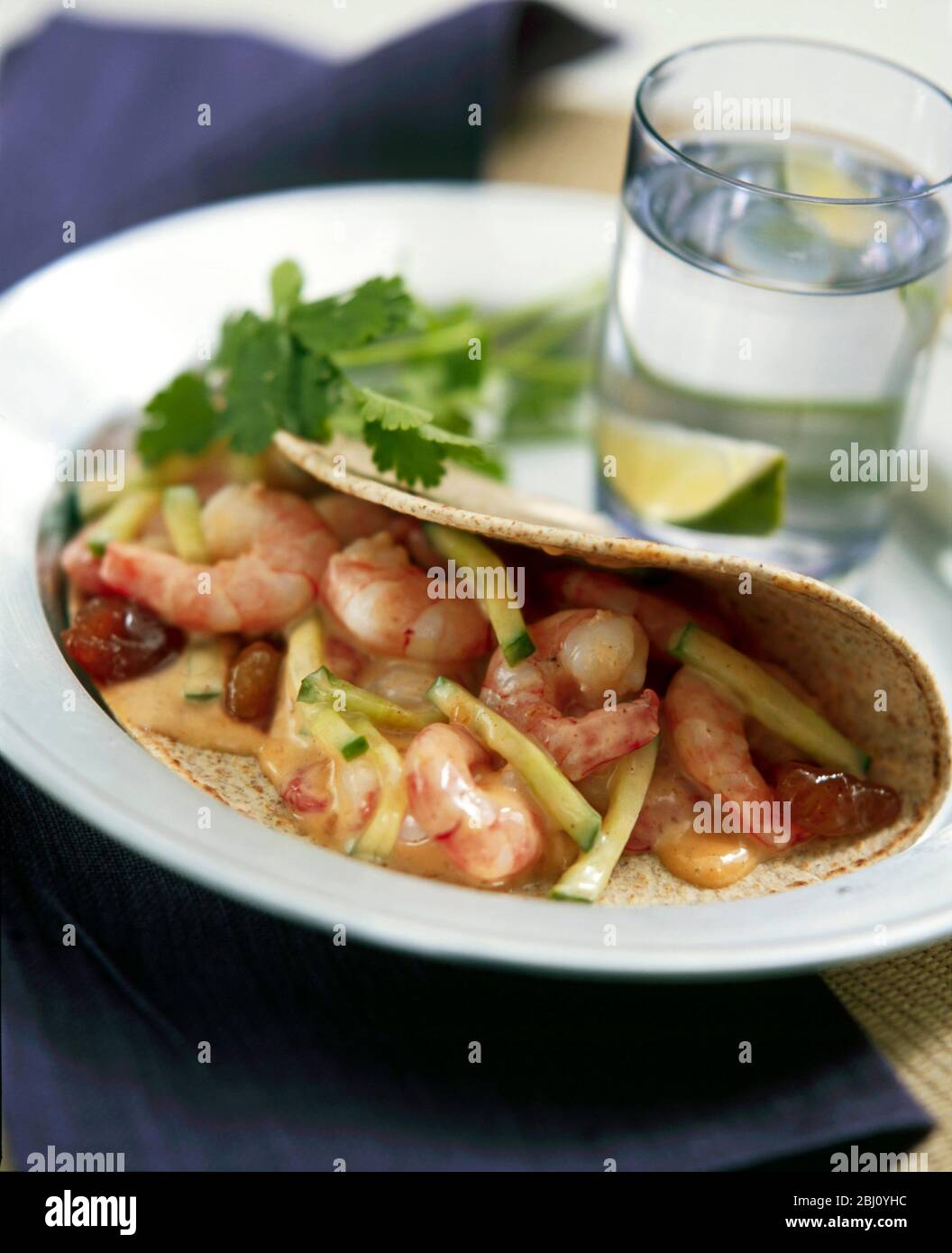 Tortilla wrap with prawns and cucmber in spicy dressing. - Stock Photo